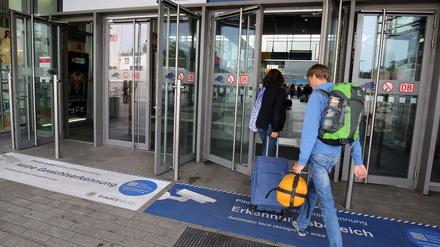 Passanten nutzen in Berlin am Bahnhof Südkreuz einen Eingang der mit "Pilotprojekt zur Gesichtserkennung" gekennzeichnet ist. 