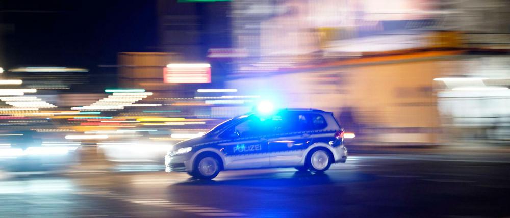 Symbolbild: Ein Polizeiauto rast mit Blaulicht durch Berlin.
