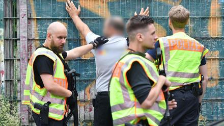 Polizisten durchsuchen am Mittwoch eine Mann an einer Berliner Grundschule in Gesundbrunnen im Bezirk Mitte. Später stellt sich heraus: falscher Alarm.