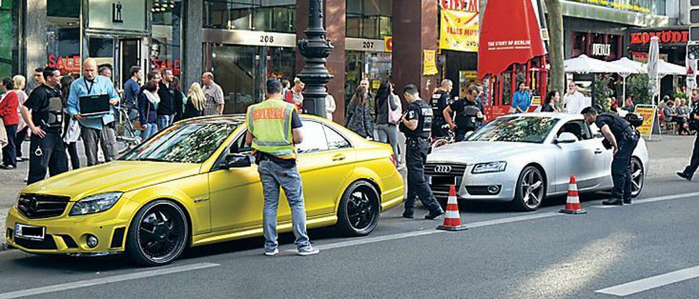Polizisten kontrollieren aufgemotzte Autos am Kurfürstendamm.