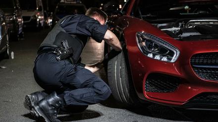 Ein Polizeibeamter überprüft vor einigen Wochen ein Fahrzeug in Berlin-Neukölln.