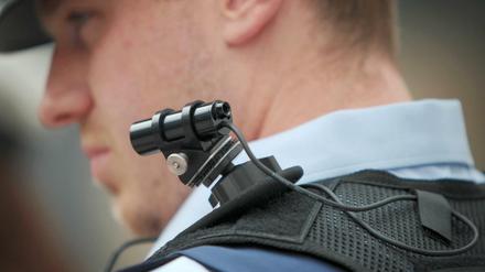 Ein Polizist trägt eine mobile Miniatur-Videokamera auf seiner Schulter. 