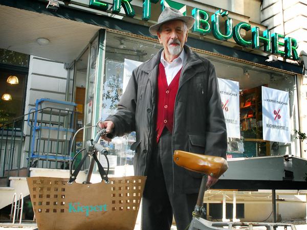 Porträt von Robert Kiepert, Gründer der Buchhandlung "Kiepert" in der Hardenbergstraße 9 a in Berlin-Charlottenburg. Fotografiert 2002 mit seinem Fahrrad und der Kiepert-Papp-Tasche vor seinem Laden. 