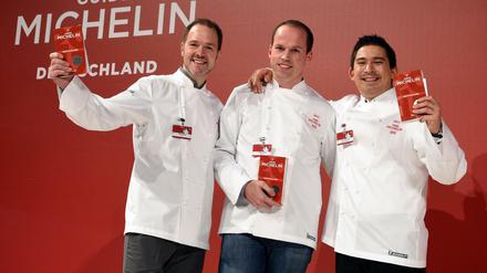 Die Chefköche Marco Müller aus Berlin, Tristan Brandt aus Mannheim und Tohru Nakamura aus München freuen sich bei der Präsentation des Restaurantführers Guide Michelin 2017 über ihre Auszeichnung mit dem zweiten Michelin Stern.