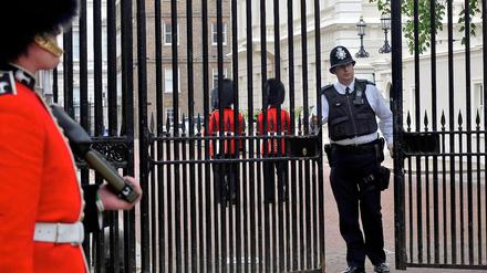 In London ist man auf große Ereignisse besser vorbereitet. Demnächst steht die Hochzeit des Prinzen an. Ein Polizist schließt die Tore vor dem St. James's Palace.