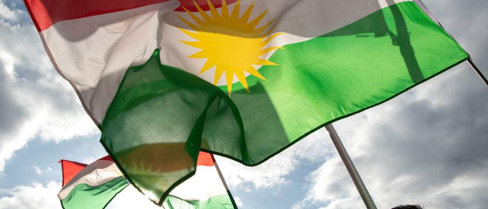 Demonstranten halten am Pariser Platz Fahnen der Autonomen Region Kurdistan.