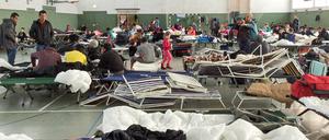 Flüchtlinge in einer Notunterkunft in einer Turnhalle.