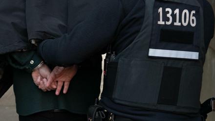 Polizeibeamte führen einen Mann nach einer Razzia gegen kriminelle Clan-Mitglieder im Jahr 2018 in Tempelhof ab.