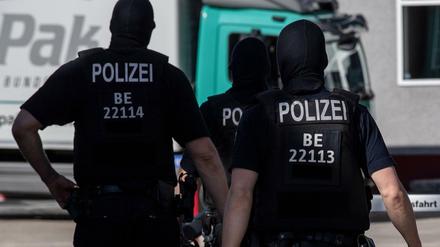 Polizisten gehen in Tempelhof vor einem Gebäude an der Colditzstraße über die Straße. 250 Einsatzkräfte der Berliner Polizei hatten im Juni 2020 insgesamt drei Objekte durchsucht, darunter eine Moschee. Es ging dabei um den Verdacht auf Subventionsbetrug in Zusammenhang mit Corona-Soforthilfen.