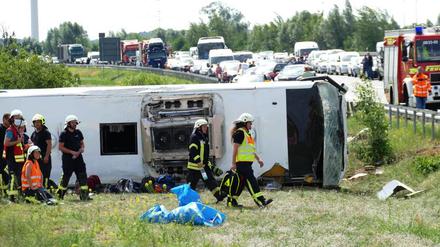 Rettungskräfte sind an der Unfallstelle im Einsatz. Der Reisebus war auf der A13 bei Schönwald südöstlich von Berlin verunglückt. 