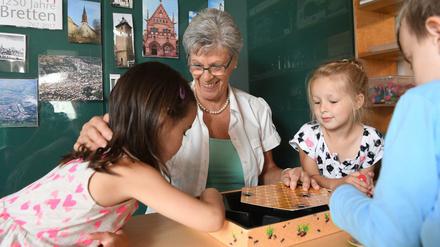 Eine Rentnerin kümmert sich in einer Kindertagesstätte um Kinder (Symbolbild).
