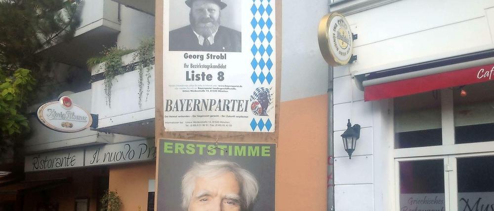 Zwei Wahlplakate hängen an einer Laterne am Südstern: Oben das des bayerischen Lokalpolitikers Georg Strobl von der Bayernpartei, darunter das des Grünen-Politikers Hans-Christian Ströbele.