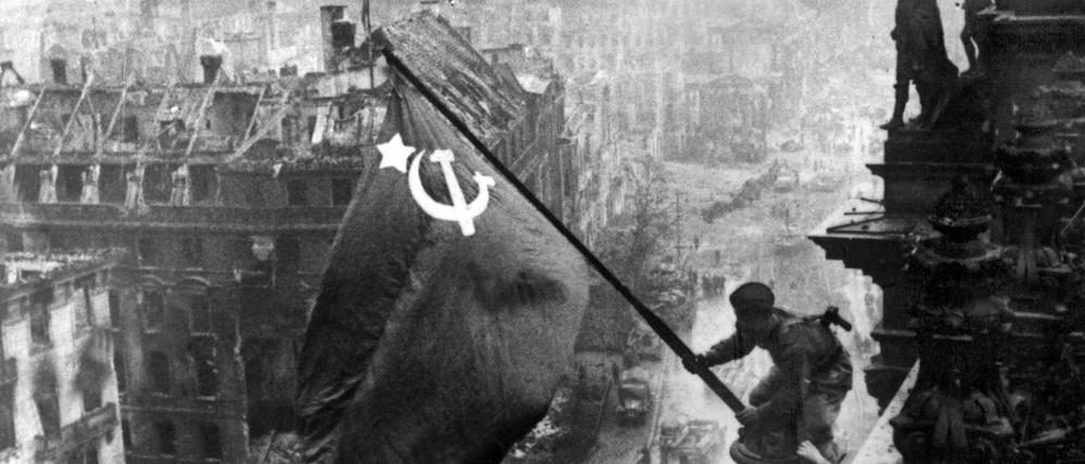 Das Bild zeigt den sowjetischen Soldaten Militon Kantarija aus Georgien, der 1945 die sowjetische Flagge auf dem Reichstag hisst.