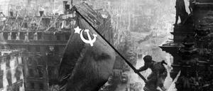 Das Bild zeigt den sowjetischen Soldaten Militon Kantarija aus Georgien, der 1945 die sowjetische Flagge auf dem Reichstag hisst.
