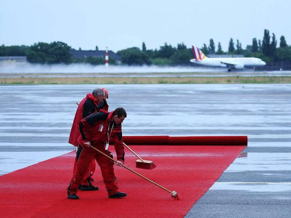 Arbeiter präparierten den roten Teppich am Flughafen Tegel.