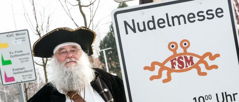 Rüdiger Weida von der «Kirche der fliegenden Spaghettimonster» steht neben seinem Schild «Nudelmesse» in Templin (Brandenburg).