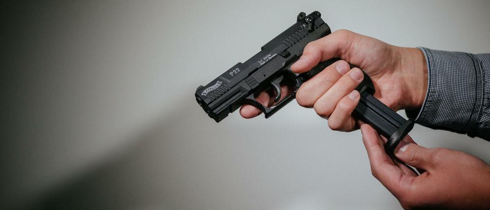 Ein Mann lädt eine Schreckschusspistole vom Typ "Walther P22" mit einem Magazin.