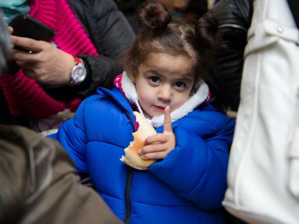 Die zweijährige Mini aus Syrien steht am 19.10.2015 in Berlin in einer Menschengruppe in einem Zelt auf dem Gelände des Landesamtes für Gesundheit und Soziales.