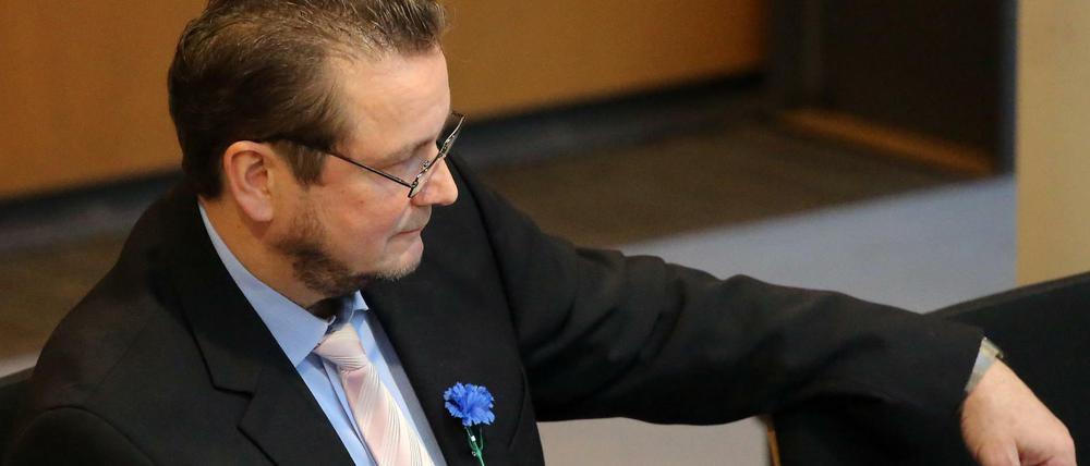 Mit einer blauen Kornblume am Revers verfolgt Andreas Wild (AfD), fraktionslos, die Fragestunde im Abgeordnetenhaus.
