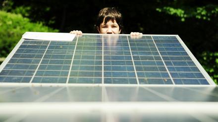 Ein Schüler in Berlin-Reinickendorf schaut über den Rand einer Solarzelle.