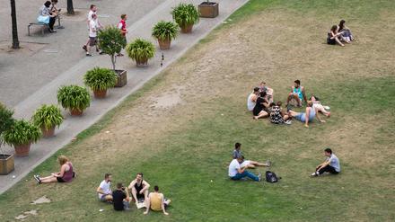 Touristen und Berliner entspannen sich im August auf einer Wiese im Lustgarten in Berlin. 