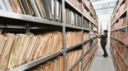 Eine Mitarbeiterin des Stasi-Museums steht in Berlin im Stasi-Archiv zwischen Regalen mit bisher nicht erfassten Unterlagen.