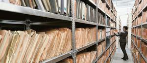 Eine Mitarbeiterin des Stasi-Museums steht in Berlin im Stasi-Archiv zwischen Regalen mit bisher nicht erfassten Unterlagen.