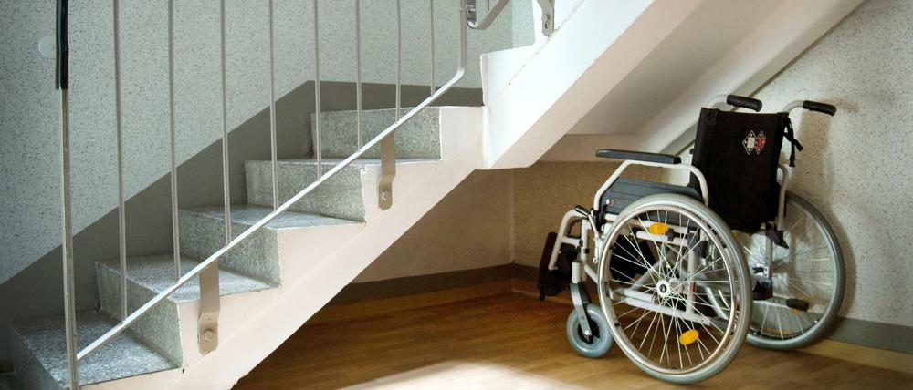 Ein Rollstuhl steht unter einer Treppe in einem Wohnhaus (Symbolbild).