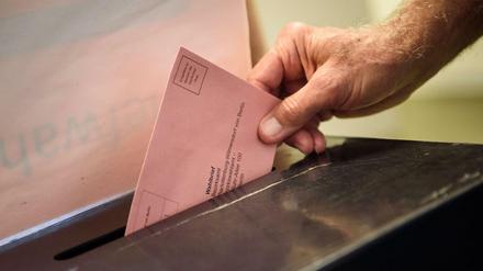 Ein Wähler wirft seinen ausgefüllten Wahlzettel in einem Wahllokal im Berliner Bezirk Charlottenburg-Wilmersdorf in eine Wahlurne. (Archivbild)