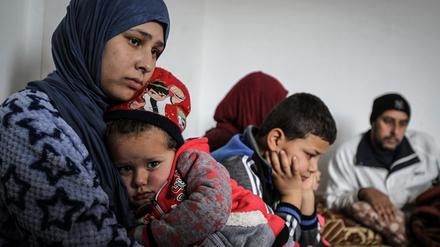 Die 19-jährige Syrerin Amal (l) umarmt ihre dreijährige Tochter Grufran neben ihrem Bruder Mohommad (M) und ihrem Vater Shihab Ahmad al-Abed (r) in einer Wohnung in Tripolis. Amals einjähriger Sohn starb bei dem Versuch, den Libanon zu erreichen. (Archivbild, 2018)