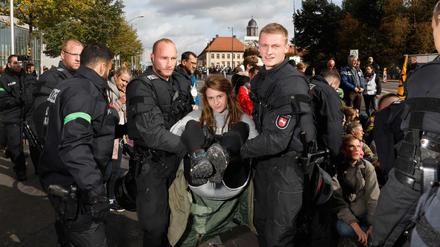 Polizisten tragen eine Aktivisten aus einer Blockade an der Mühlendammbrücke. Die Frau wehrt sich nicht.