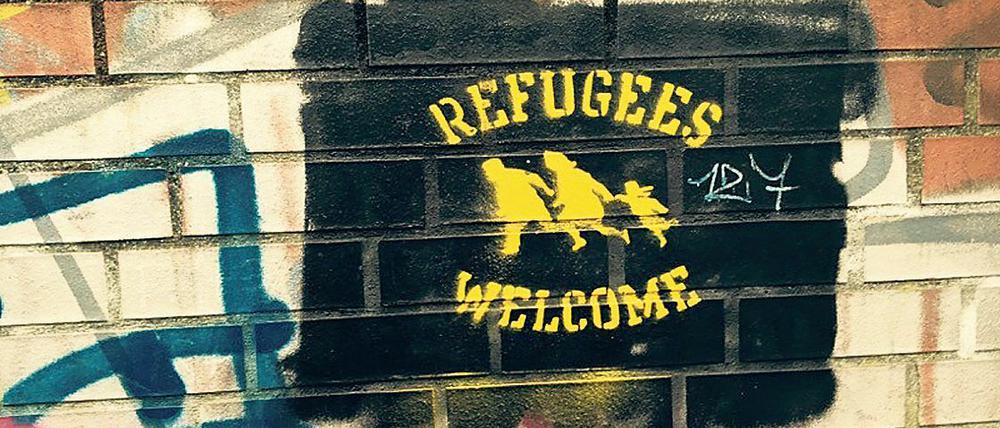 Ein Refugees Welcome Grafitti wurde an eine Backsteinmauer gesprayt.