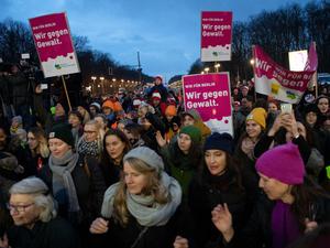 Teilnehmer an der Tanz-Demo "One billion Rising Revolution" stehen am Brandenburger Tor.