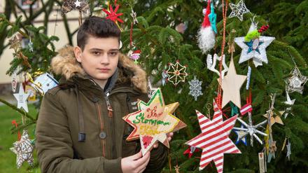 Timo zeigt Sterne aus verschiedenen Ländern am Weihnachtsbaum im heimischen Beeskow. 