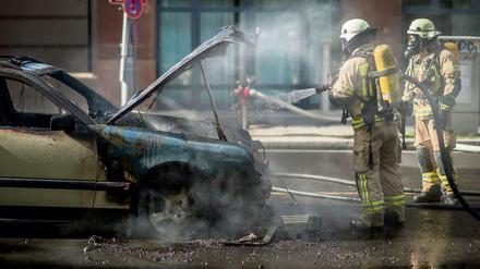 Einsatzkräfte der Feuerwehr löschen ein brennendes Taxi in der Dorotheenstraße im Regierungsviertel in Berlin. Der Polizei zufolge war ein technischer Defekt die Brandursache. Der Taxifahrer wurde bei dem Feuer nicht verletzt. 