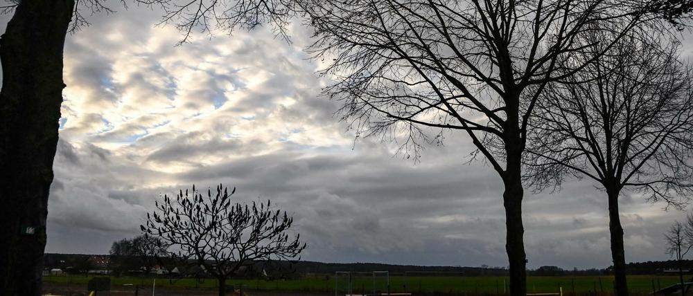 Nur ein kleine Wolkenlücke zeigt sich zwischen grauen Regenwolken über einem Feld im brandenburgischen Zauchwitz. Das kalte und regnerische Wetter soll in den nächsten Tagen anhalten, teilweise ist Schnee vorhergesagt. Foto: Jens Kalaene/dpa