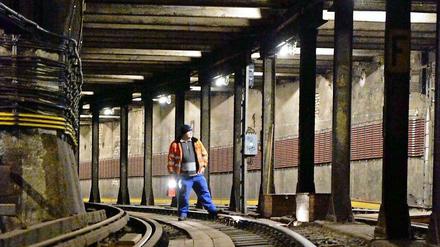 Blick in den Tunnel der U-Bahnlinie 2, in der ein Arbeiter auf den Schienen steht.