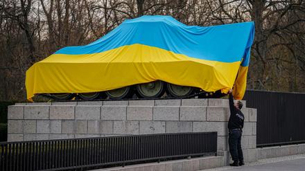 Polizeibeamte entfernen am Mittwochmorgen die Flagge der Ukraine von einem historischen Panzer am Sowjetischen Ehrenmal an der Straße des 17. Juni. Zuvor war der Panzer in die ukrainische Flagge gehüllt.