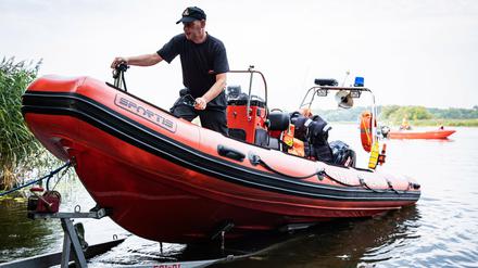 Feuerwehrleute in einem Boot ziehen bei Stettin tote Fische aus der Oder. Seit mehr als einer Woche beschäftigt das massive Fischsterben im Fluss die Behörden und Anwohner.
