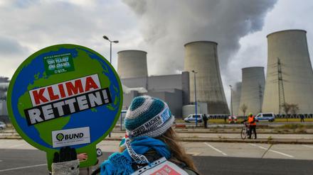 Der Kälte getrotzt. Eine Umweltaktivistin vor den Kühltürmen des Braunkohlekraftwerkes Jänschwalde in der Lausitz.
