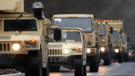 US-Militärfahrzeuge fahren in Brandenburg auf der Straße eines Truppenübungsplatzes.