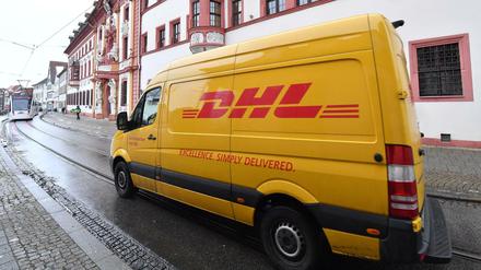 Ein Transporter mit DHL-Logo fährt in Erfurt an der Thüringer Staatskanzlei vorbei.