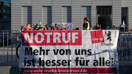 NOTRUF steht in Großbuchstaben auf einem Transparent am Bettenhaus der Charité. Beschäftigte aller landeseigenen Berliner Kliniken streiken seit dem 7. September. Bei den Vivantes-Töchtern schwelt nun der Tarifstreit weiter.