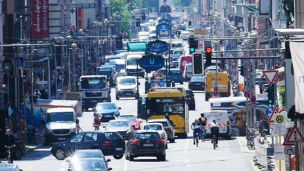 Autos, Busse, Lastwagen, Radfahrer und Fußgänger teilen sich die Friedrichstraße am Checkpoint Charlie zur Mittagszeit. 