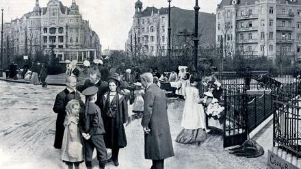 Eine Menschengruppe steht um 1902 auf der Straße am neuen Viktoria-Luise-Platz in Schöneberg