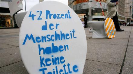 Mit bemalten Klobrillen, Pappfiguren und Schildern wiesen Jugendliche auf dem Alexanderplatz darauf hin, dass mehr als ein Drittel der Menschheit keine Toiletten habe.
