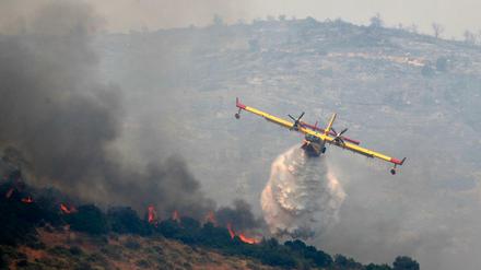  Von einem Flugzeug aus wird ein Waldbrand gelöscht.