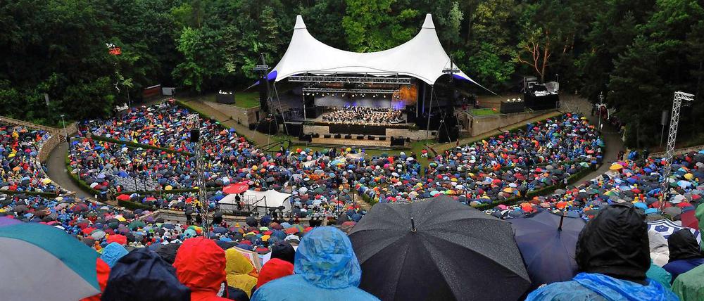 Konzert der Philharmoniker in der Waldbühne: Mit Schirmen und Regencapes trotzen diese Musikfreunde dem schlechten Wetter.