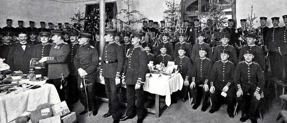 Eine Gruppe von Offizieren und Soldaten hat sich zu Weihnachten vor dem Gabentisch versammelt. 