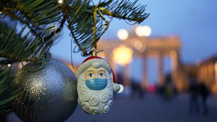 Weihnachtsmann mit Mundschutz vor dem Brandenburger Tor in Berlin